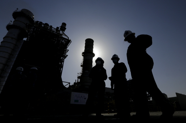사우디아라비아 국영 석유회사 아람코가 아시아와 유럽 원유가격을 2월에 이어 3월에도 인상했다. 사진은 지난 2021년 아람코 기술자들이 리야드에서 150㎞ 떨어진 쿠라이스 유전의 가스 터빈 발전기 앞을 걷고 있는 모습.